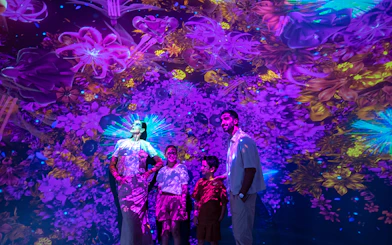Visitors enjoying vibrant digital art at Source installation, AYA Universe.