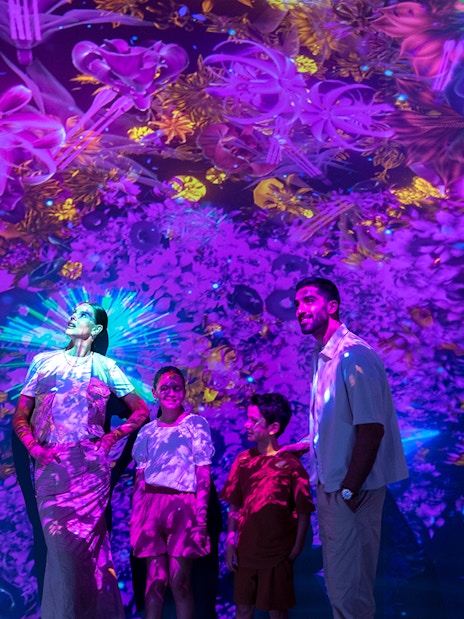 Visitors enjoying vibrant digital art at Source installation, AYA Universe.