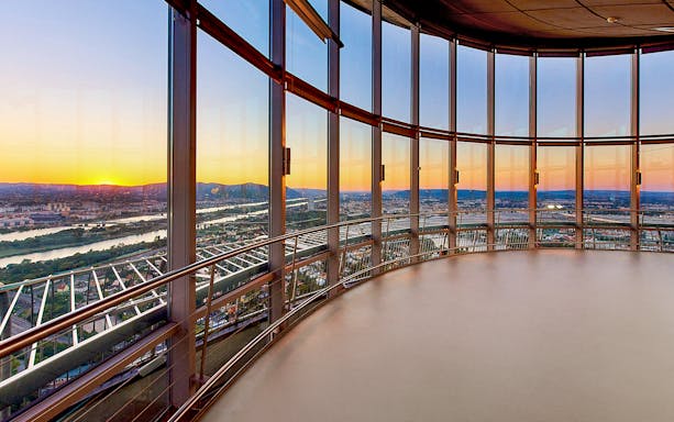Panoramic view from Danube Tower overlooking Vienna at sunset.