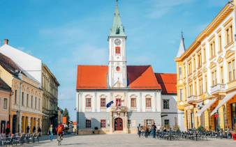 Historic town square with clock tower and classical buildings in Varazdin, Croatia.