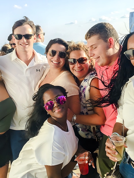 Group enjoying a cruise with New York City skyline in the background.