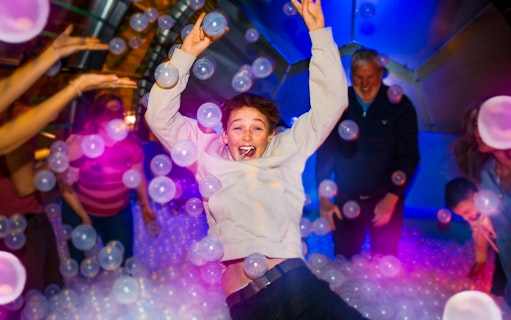 Person enjoying bubble room experience at Tivoli Gardens' The Tube in Copenhagen.