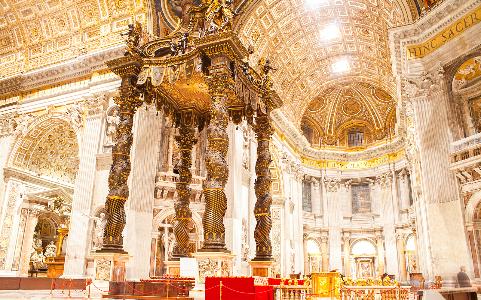 St. Peter's Basilica exterior view in Vatican City with tourists exploring the square.