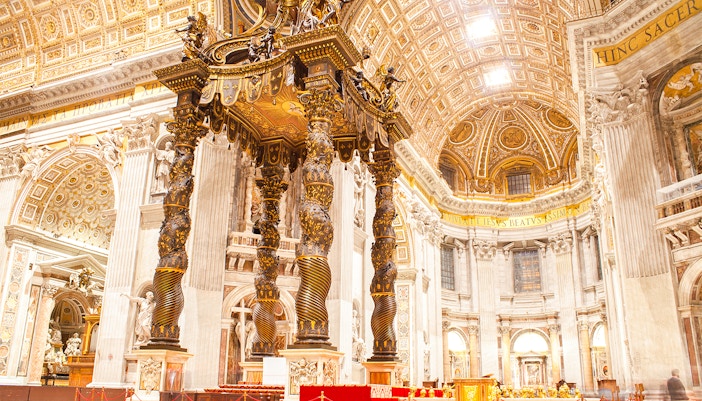 St. Peter's Basilica exterior view in Vatican City with tourists exploring the square.