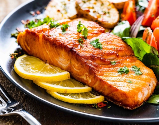 Grilled salmon with lemon slices and salad at Atmosphere restaurant, Burj Khalifa.
