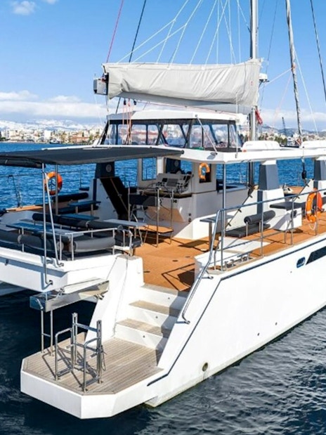 Catamaran on Santorini Caldera cruise with seating and sunshade.