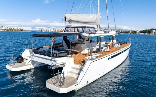 Catamaran on Santorini Caldera cruise with seating and sunshade.