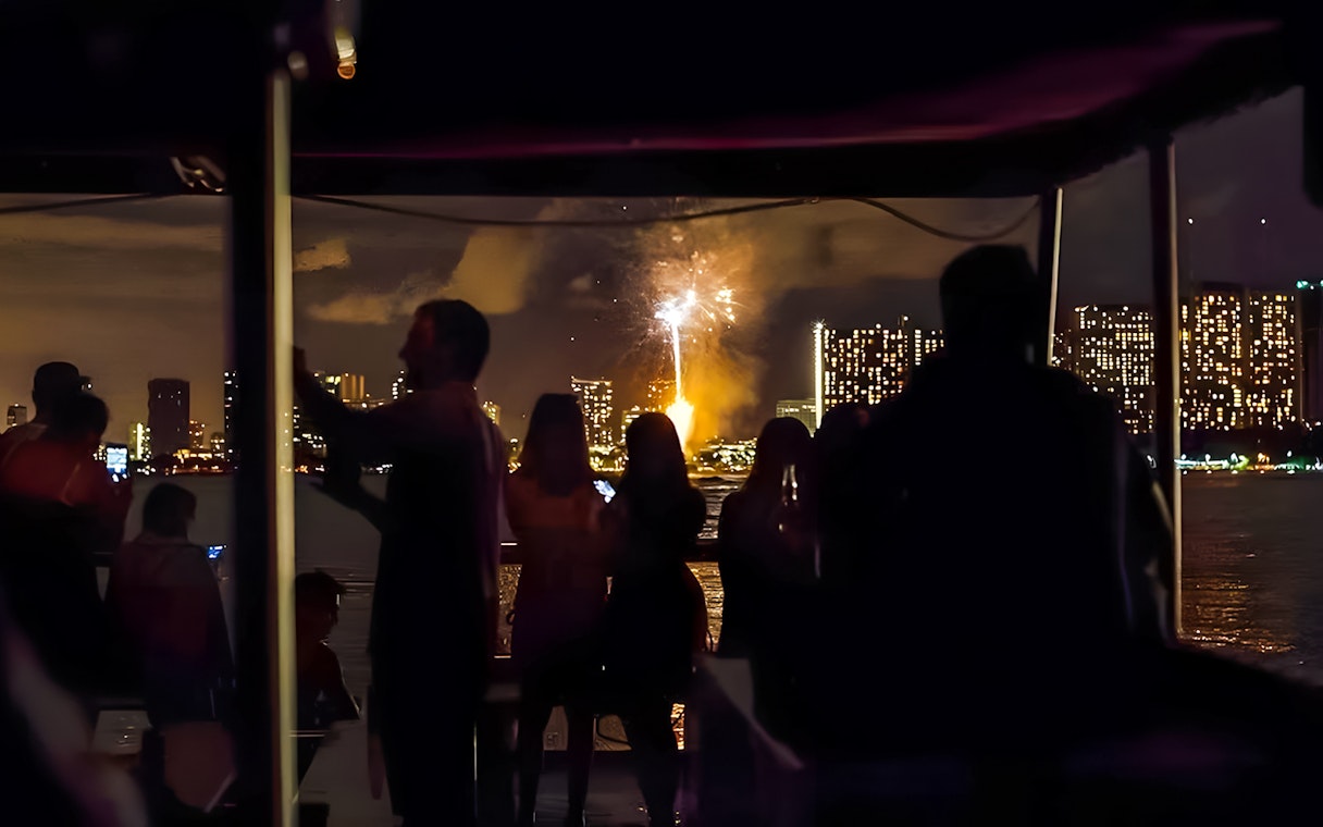 Guests watching fireworks over Waikiki skyline, Honolulu, Hawaii.