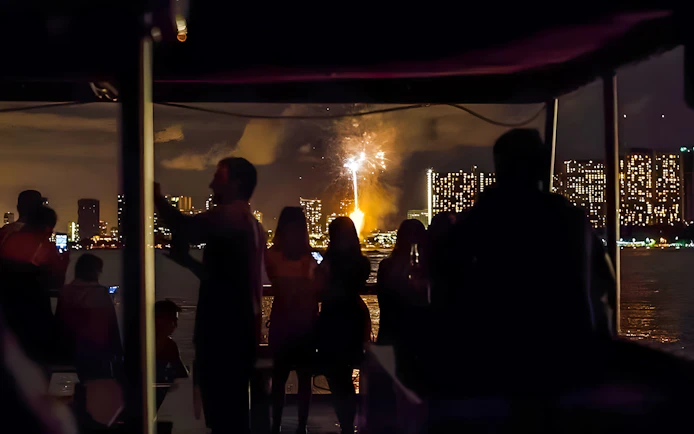 Guests watching fireworks over Waikiki skyline, Honolulu, Hawaii.