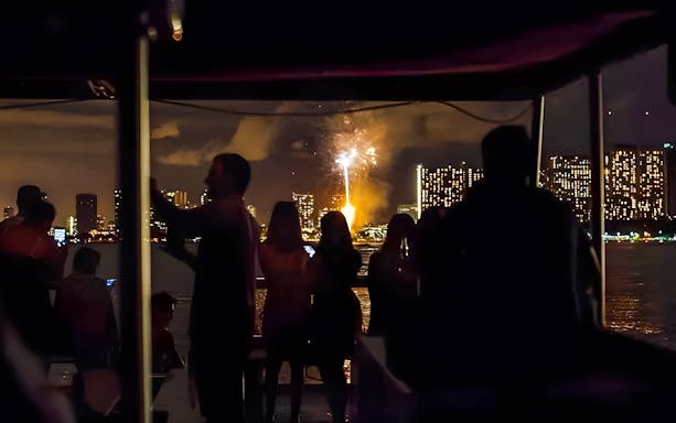 Guests watching fireworks over Waikiki skyline, Honolulu, Hawaii.
