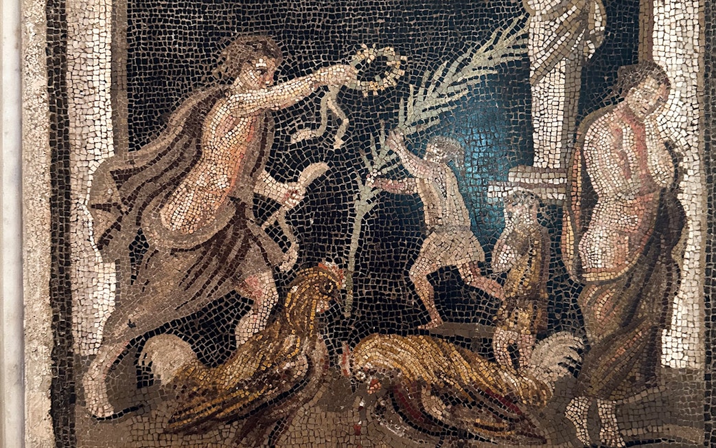 Ancient mosaic depicting figures and roosters at Naples National Archaeological Museum.