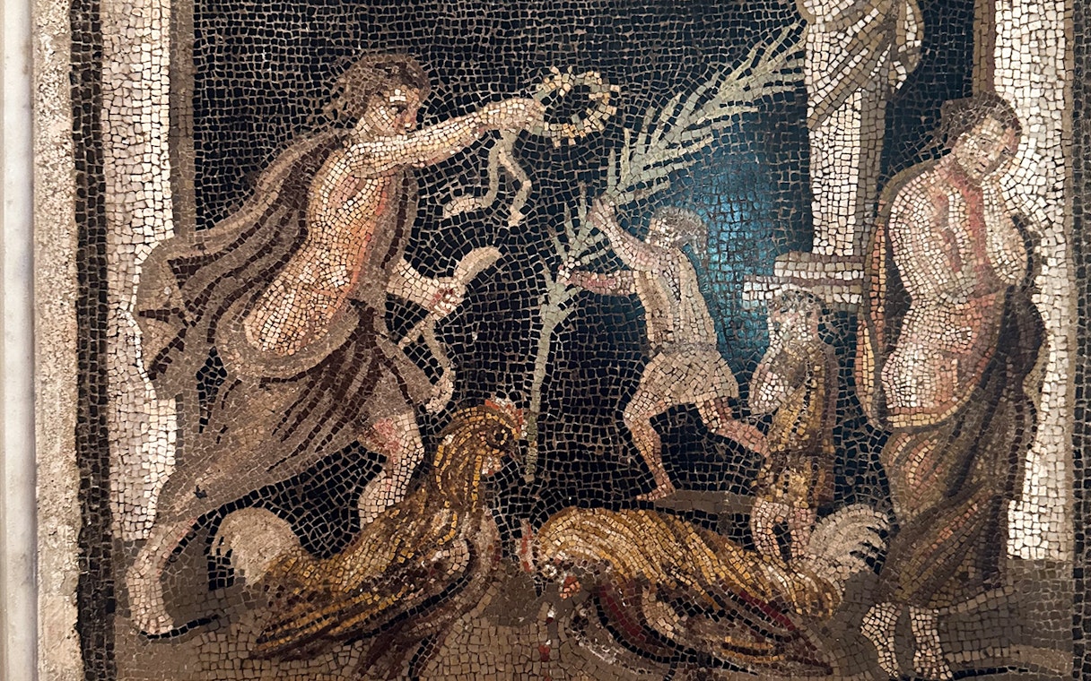 Ancient mosaic depicting figures and roosters at Naples National Archaeological Museum.