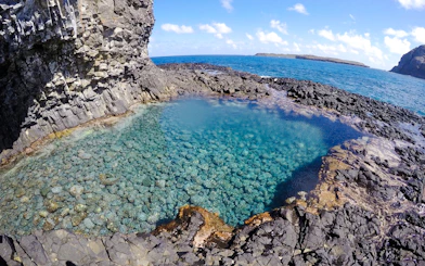 Natural pool with clear water and rocky surroundings at Buraco do Galego, Noronha.
