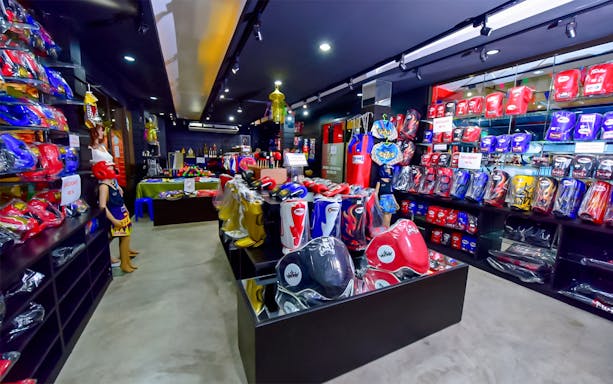 Merchandise display at Patong Boxing Stadium shop with boxing gloves and gear.