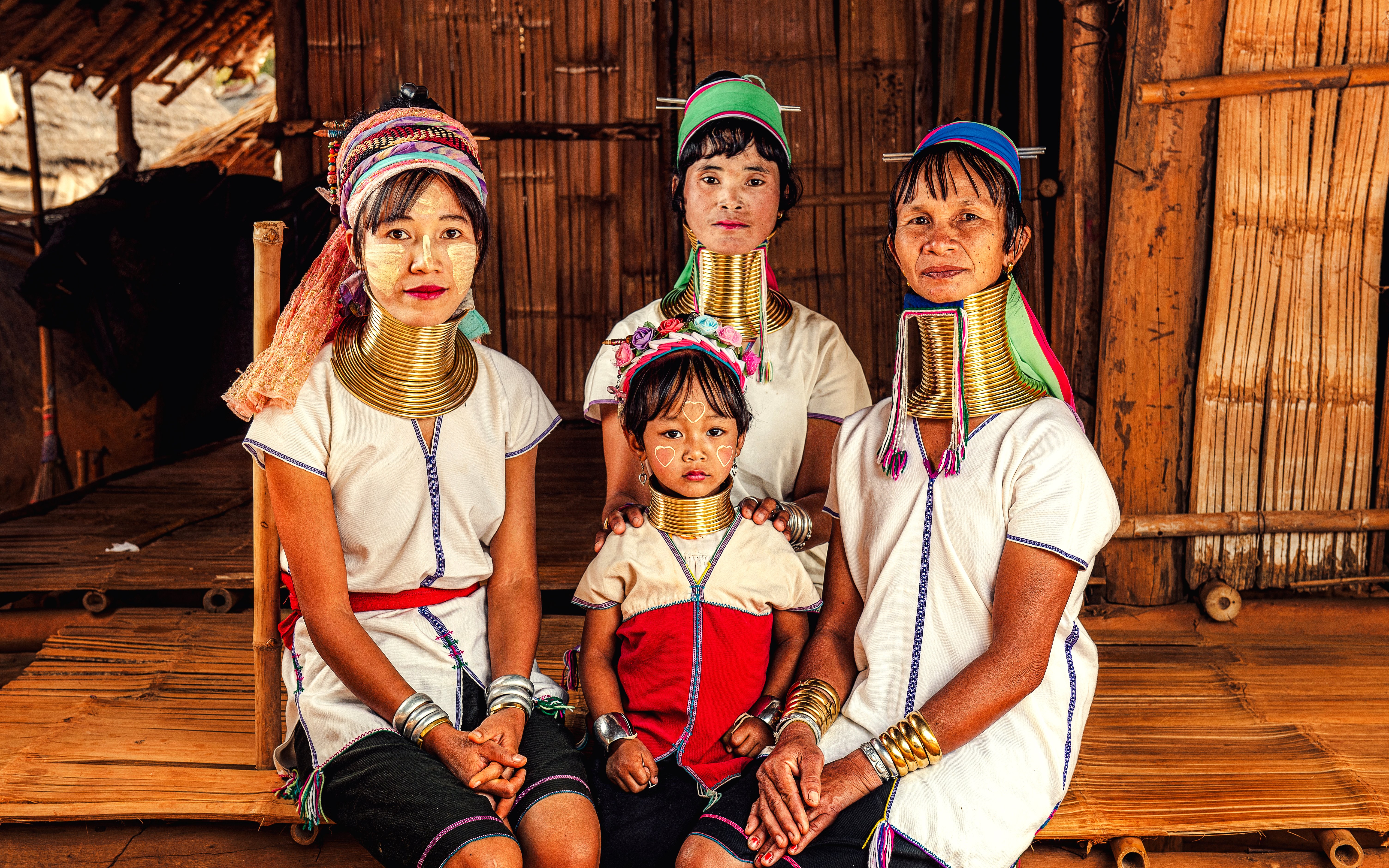 Women and child in traditional attire with neck rings, Karen Long Neck Village, Chiang Rai, Thailand.