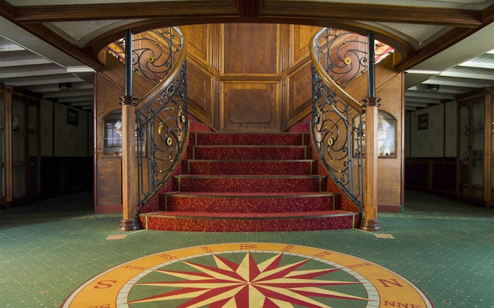 Elegant staircase on Budapest Danube River evening cruise ship interior.