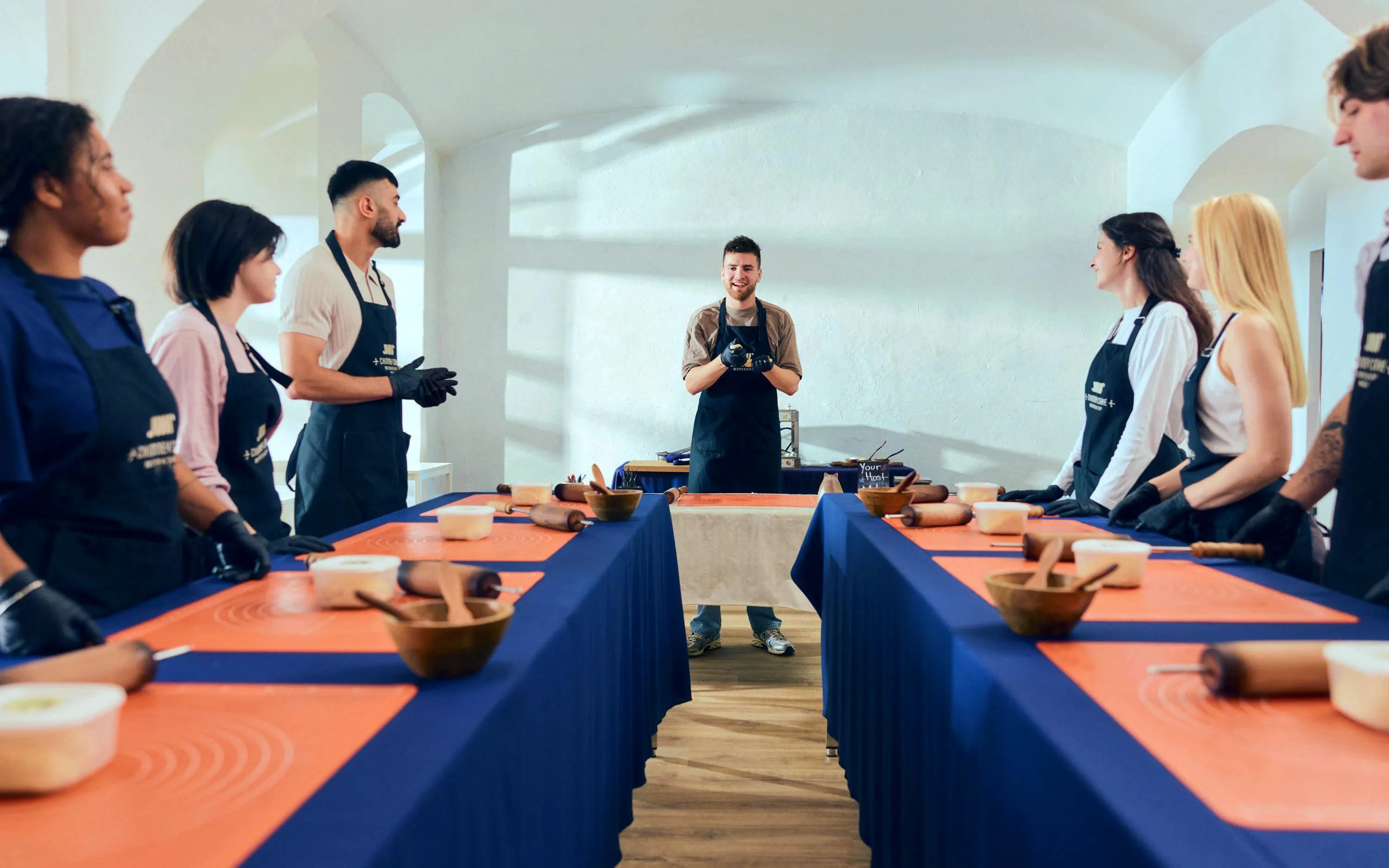Participants at a Chimney Cake workshop in Budapest, learning to make Kürtőskalács.