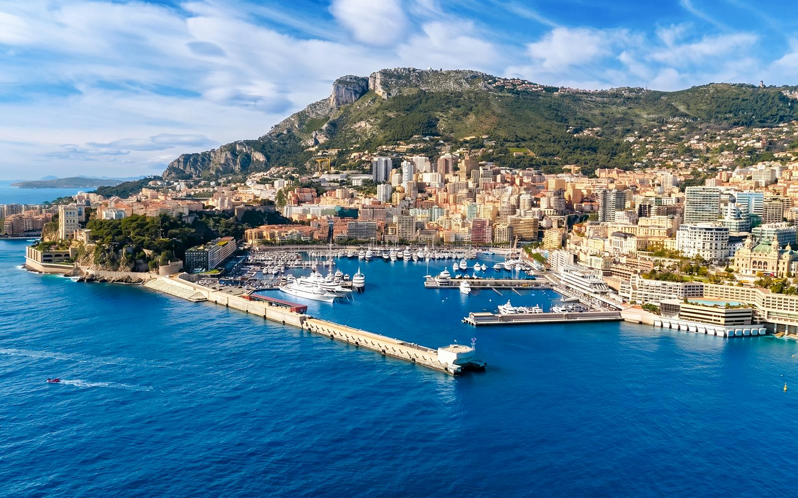 Monaco harbor with yachts and cityscape, view from a boat tour.