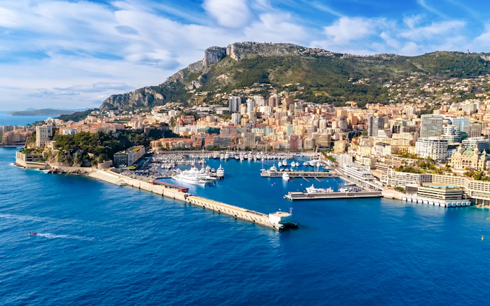 Monaco harbor with yachts and cityscape, view from a boat tour.