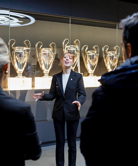 Guide explaining trophies at Santiago Bernabéu Stadium tour.