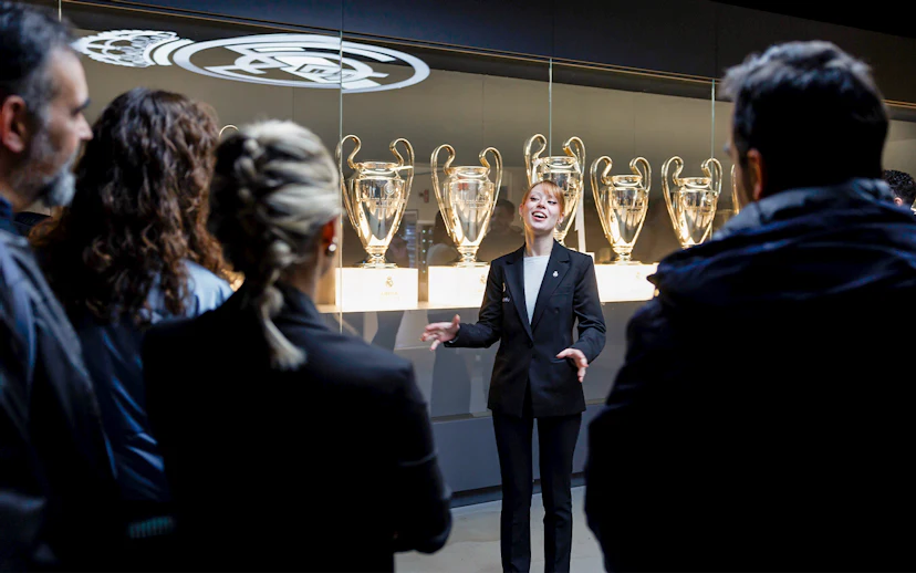 Guide explaining trophies at Santiago Bernabéu Stadium tour.