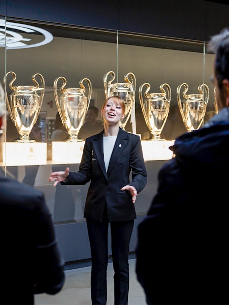 Guide explaining trophies at Santiago Bernabéu Stadium tour.