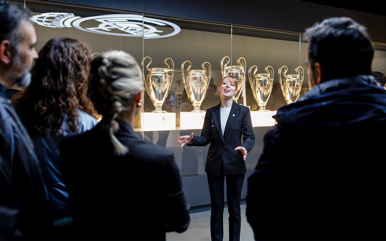 Guide explaining trophies at Santiago Bernabéu Stadium tour.