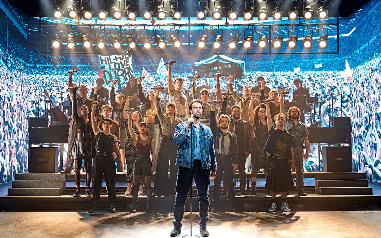 Group performance on stage at Just for One Day event.