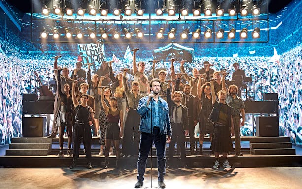 Group performance on stage at Just for One Day event.