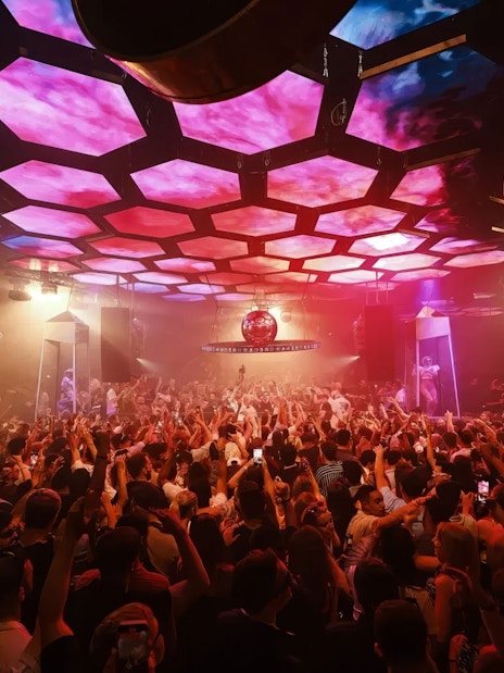 DJ performing at Music On event, Pacha Ibiza nightclub, with vibrant crowd and lighting.