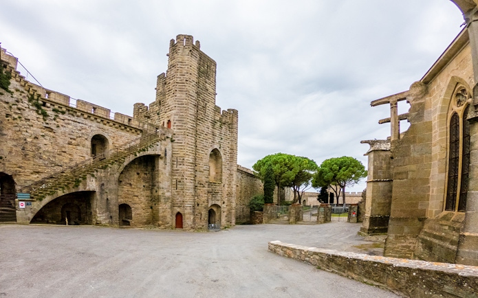 Carcassonne Castle courtyard with stone tower and Saint-Nazaire Basilica, France.