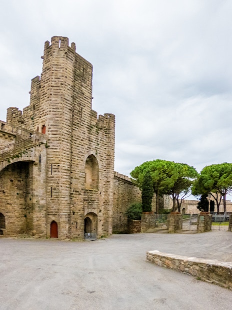 Carcassonne Castle courtyard with stone tower and Saint-Nazaire Basilica, France.