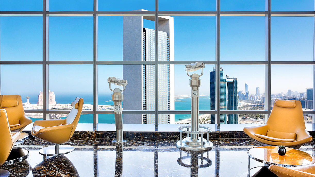 Observation deck view of Abu Dhabi skyline from Etihad Towers with telescopes and seating.