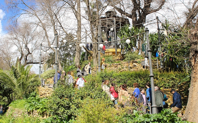 Group of tourists exploring María Luisa Park in Seville during a guided tour.