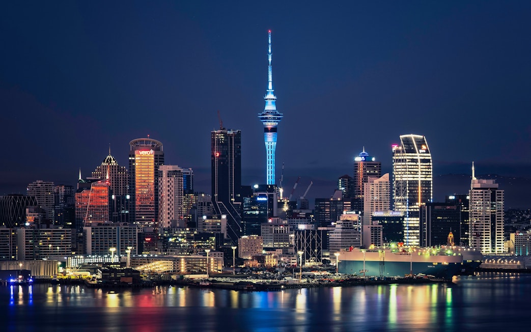 Auckland city skyline with Sky Tower illuminated at night, New Zealand.