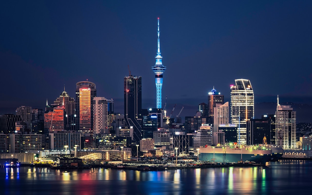 Auckland city skyline with Sky Tower illuminated at night, New Zealand.