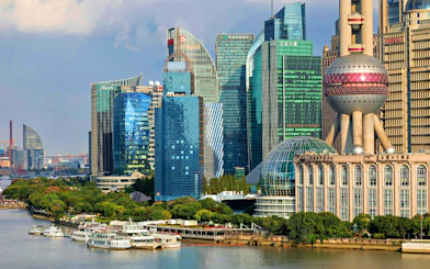 Cruise ships on Huangpu River with Shanghai skyline, including Oriental Pearl Tower.