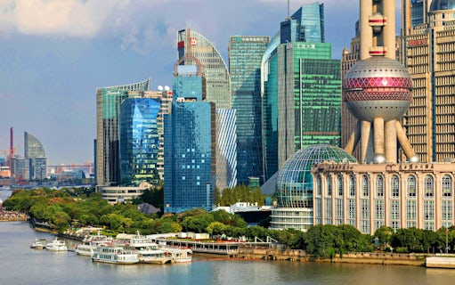 Cruise ships on Huangpu River with Shanghai skyline, including Oriental Pearl Tower.