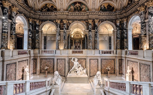 Kunsthistorisches Museum interior with grand staircase and marble sculptures.