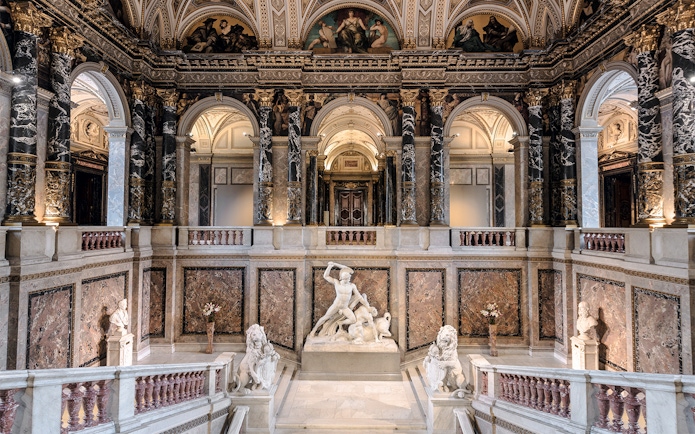 Kunsthistorisches Museum interior with grand staircase and marble sculptures.