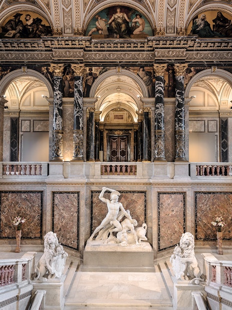 Kunsthistorisches Museum interior with grand staircase and marble sculptures.
