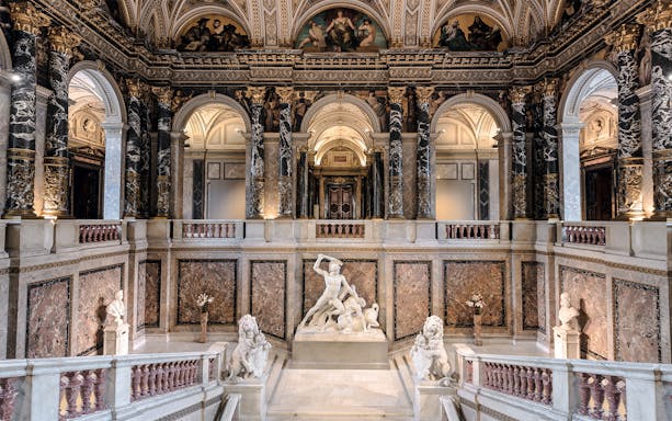 Kunsthistorisches Museum interior with grand staircase and marble sculptures.