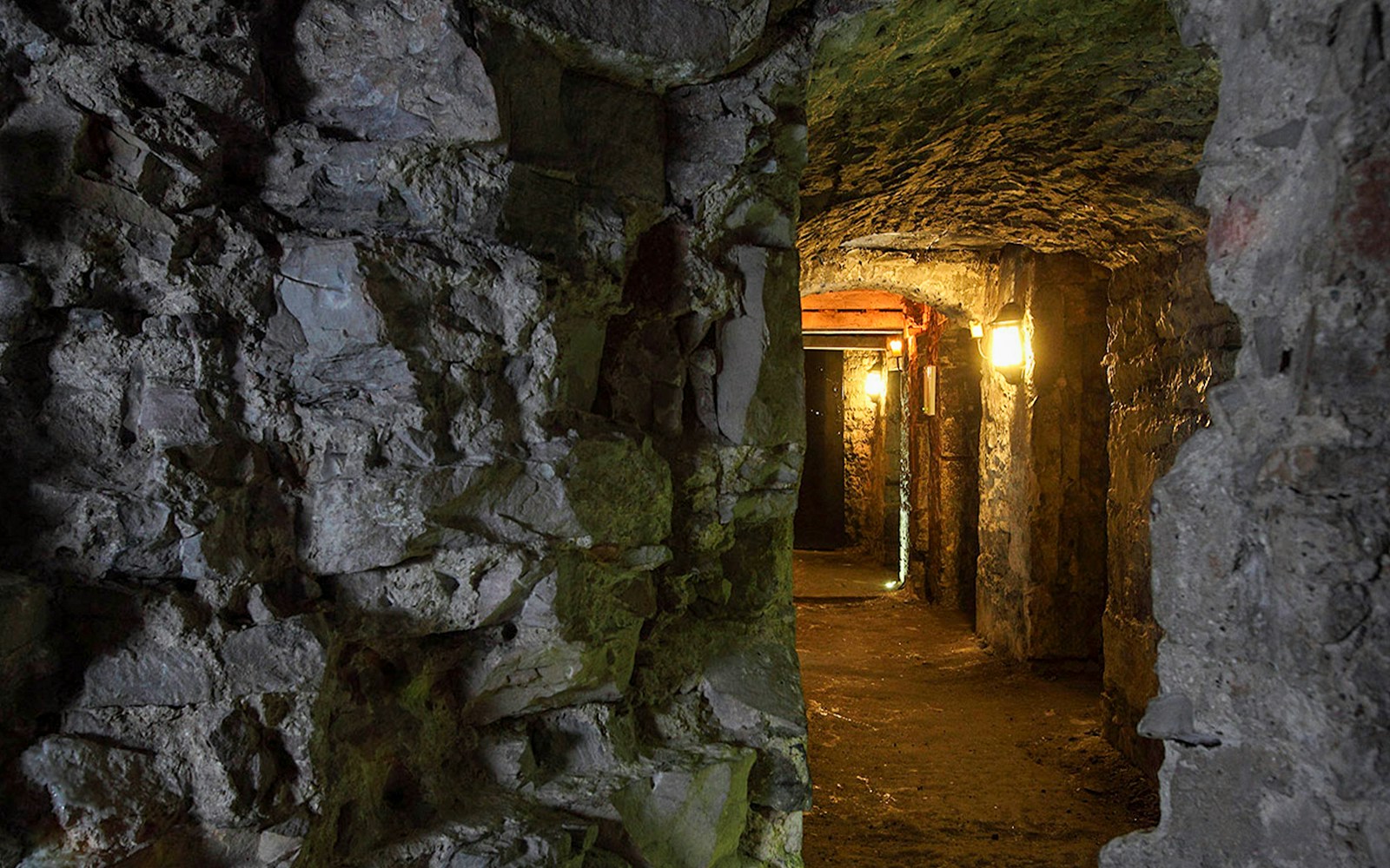 Edinburgh underground vaults with stone walls and dim lighting.