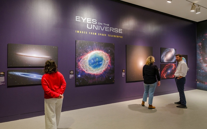 Visitors viewing space images at the Eyes on the Universe exhibit, American Museum of Natural History.