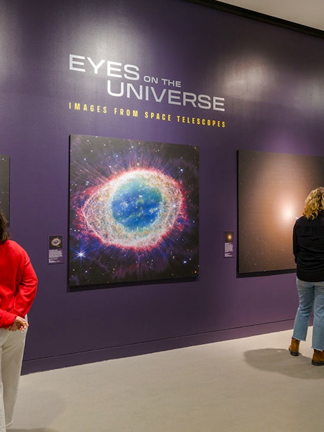 Visitors viewing space images at the Eyes on the Universe exhibit, American Museum of Natural History.