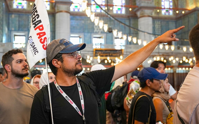 Guests with a guide inside the Blue Mosque, Istanbul, observing architecture.