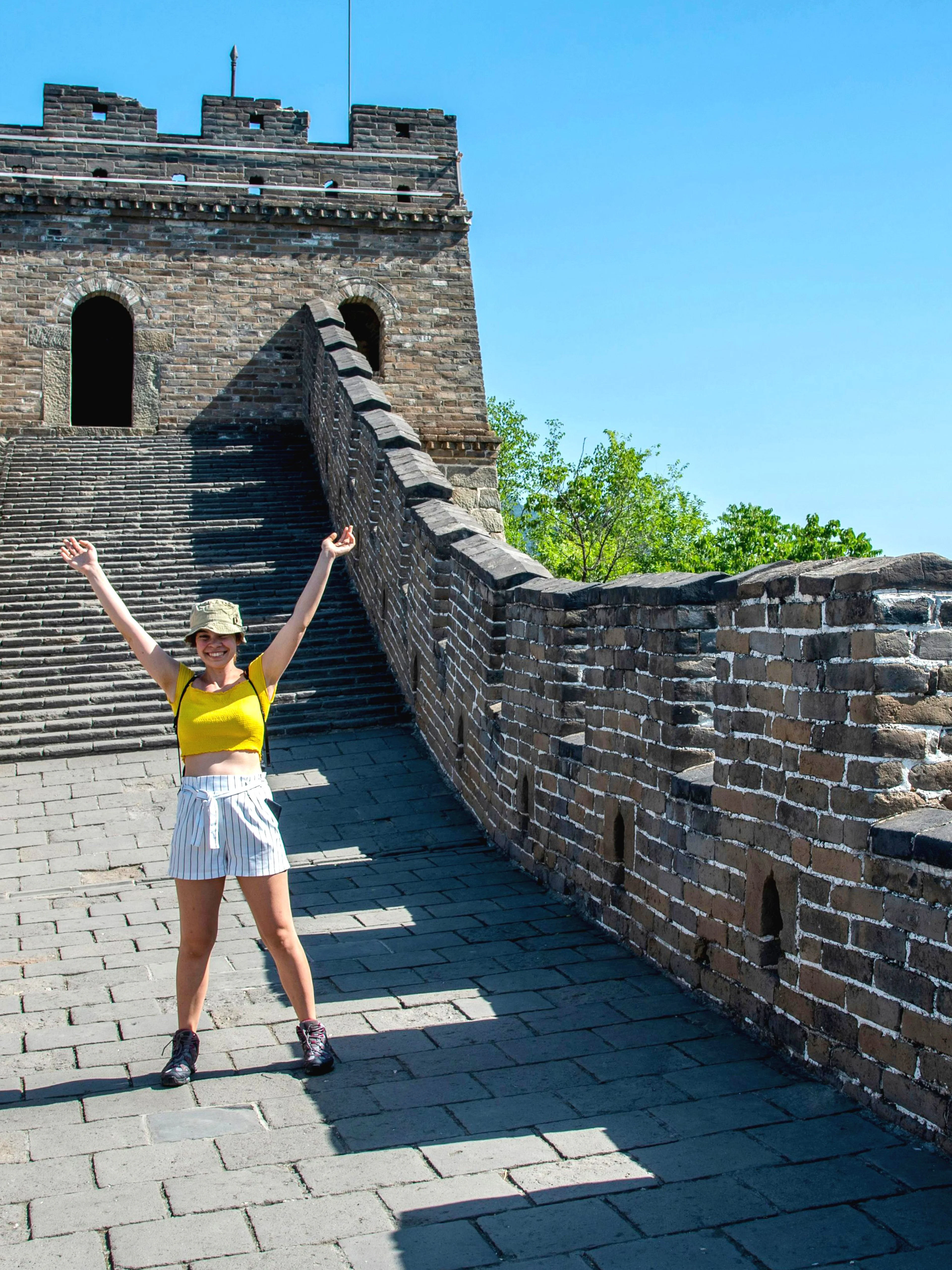 Visitor on Mutianyu section of the Great Wall of China near Beijing, standing on the ancient stone pathway.