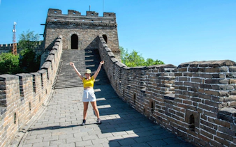 Visitor on Mutianyu section of the Great Wall of China near Beijing, standing on the ancient stone pathway.