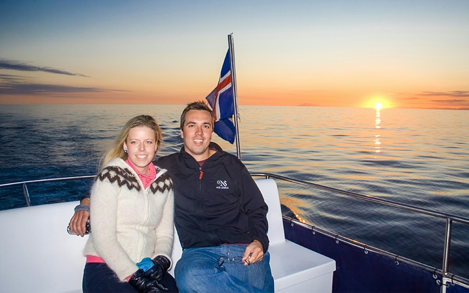 Couple sitting on boat in Reykjavik on their Midnight Sun Whale Watching Tour