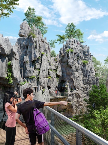 Visitors on a walkway exploring rocky terrain in Rainforest Wild Asia.